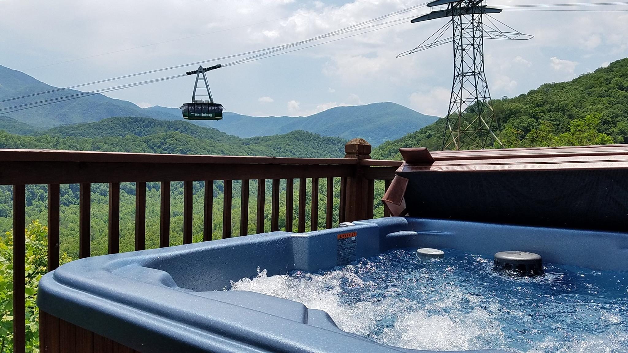 Bubbling hot tub on a Gatlinburg cabin deck overlooking the Smoky Mountains and the aerial tramway