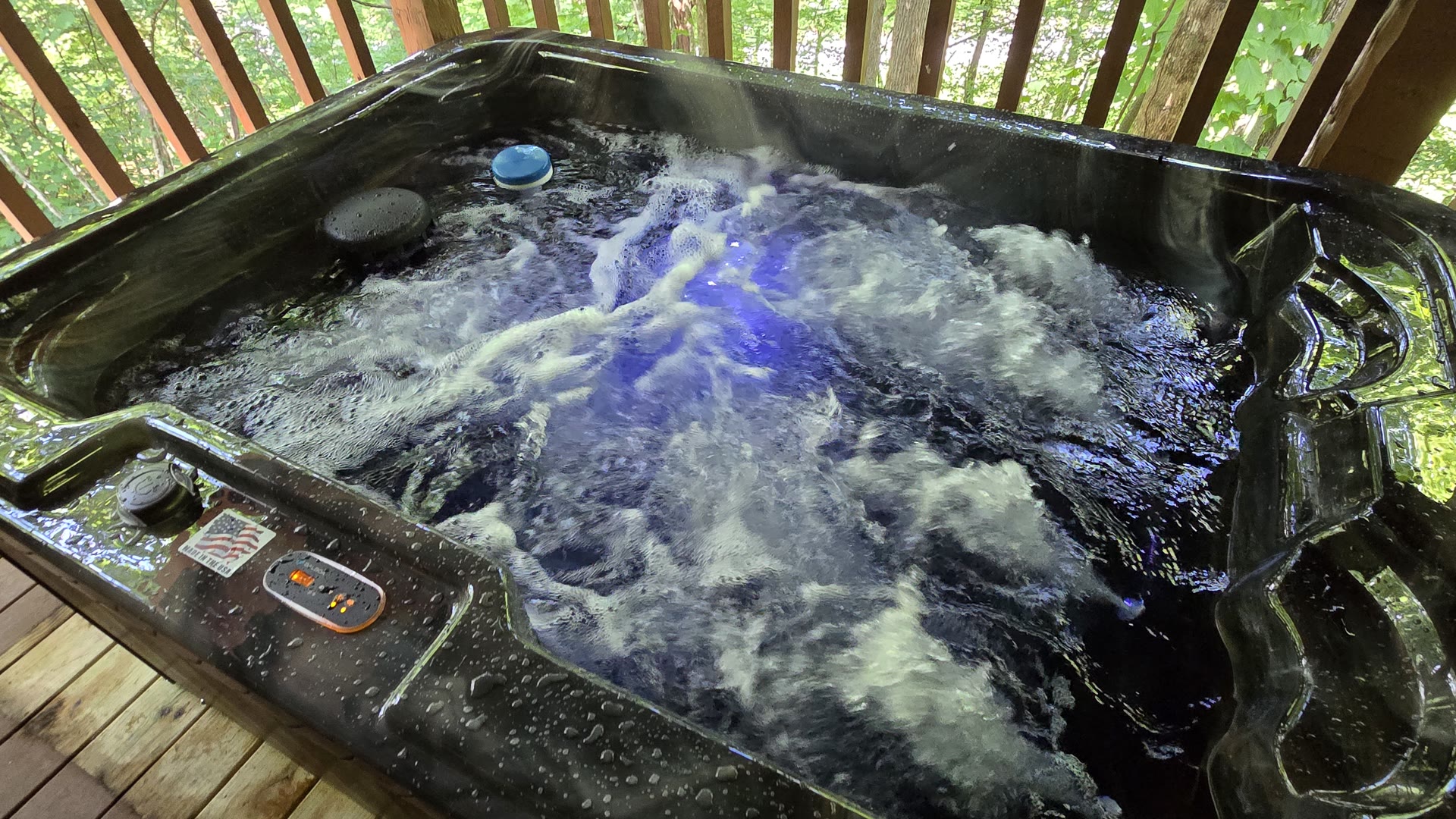 New hot tub bubbling on a wooded cabin deck