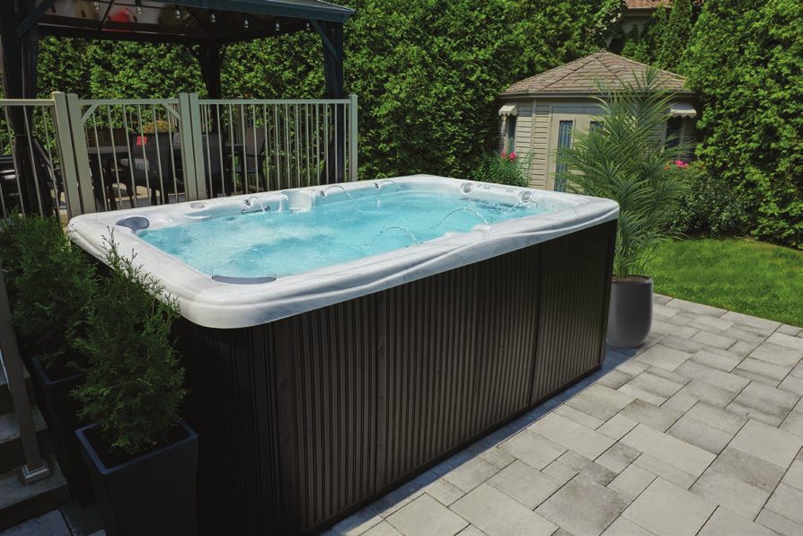 Swim spa with a gray cabinet in a fenced backyard