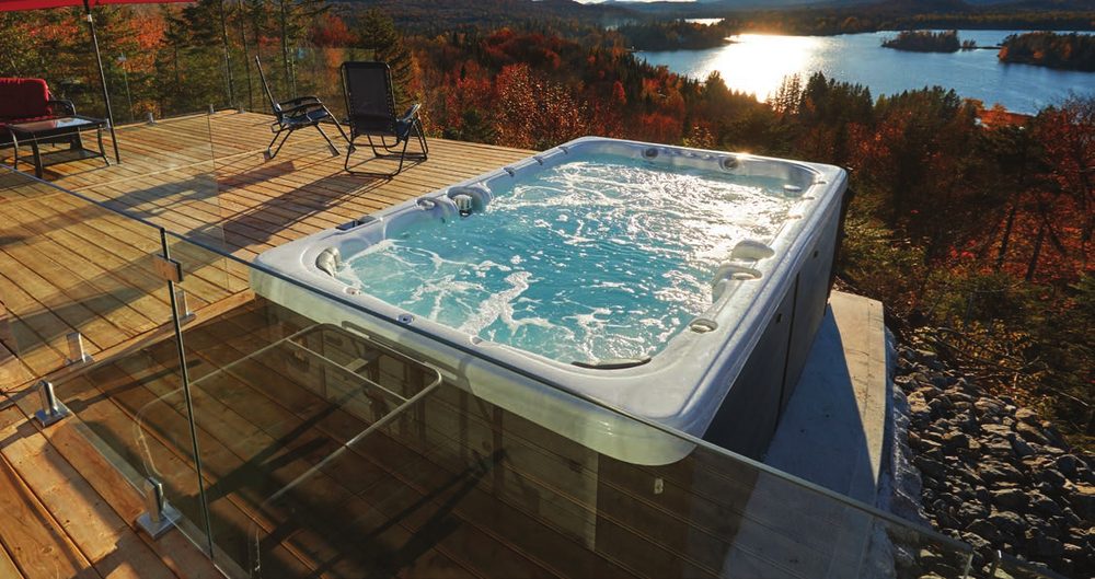 Swim spa on a deck overlooking a lake at sunset
