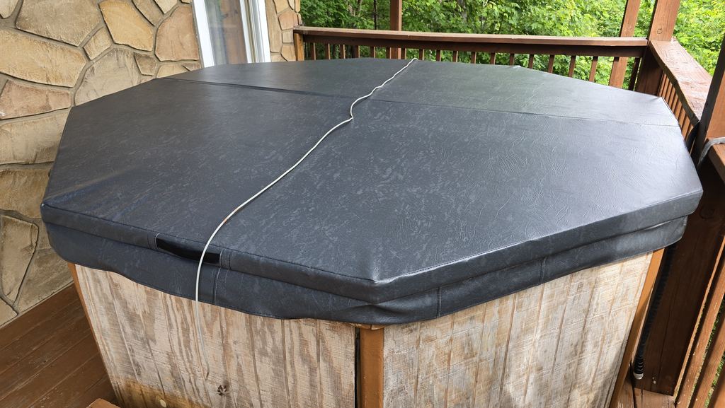 Custom gray cover on an octagon wood hot tub on a cabin deck