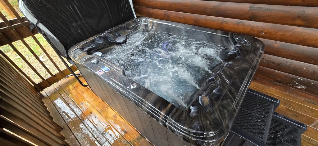 Hot tub with every jet running on a log cabin deck