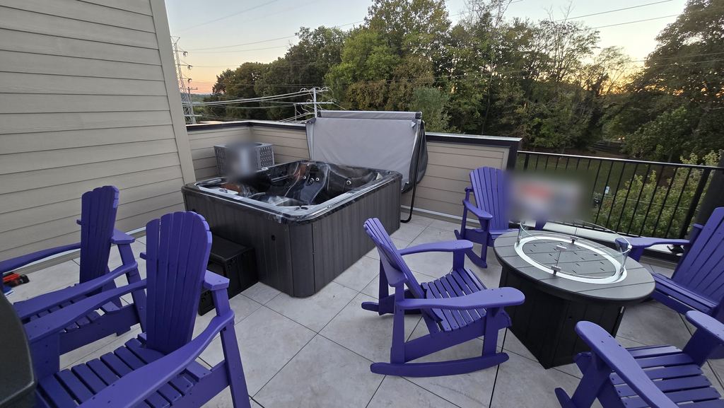 Rooftop patio at sunset with a new hot tub, purple Adirondack chairs and a fire table